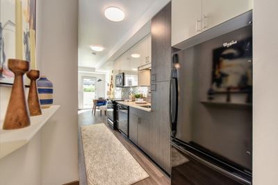 Kitchen Alley with Hardwood Inspired Floor, Rug, Wood Cabinents and Refrigerator